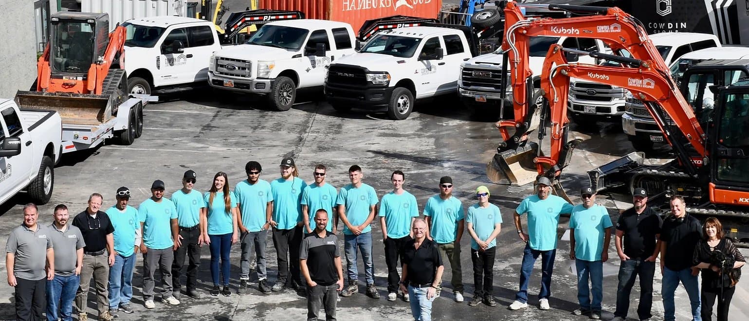 The Cowdin Construction crew in front of the company fleet and excavators